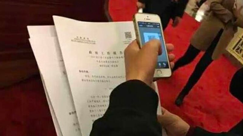 Un periodista escanea el código QR del Informe de Trabajo